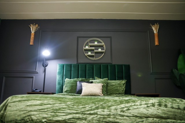 bed in deluxe room with black wall.